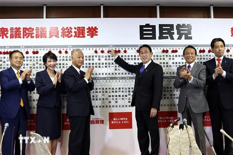 Thủ tướng Nhật Bản, Chủ tịch LDP Fumio Kishida gắn hoa bên cạnh tên của những ứng cử viên trúng cử trong cuộc bầu cử Hạ viện tại Tokyo ngày 31/10/2021. (Ảnh: AFP/TTXVN) 