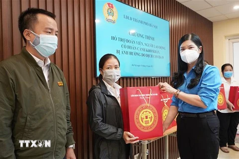Lãnh đạo Liên đoàn Lao động thành phố tặng quà cho đoàn viên công đoàn, người lao động bị ảnh hưởng do dịch COVID-19 trên địa bàn quận Hoàn Kiếm. (Ảnh TTXVN phát) 