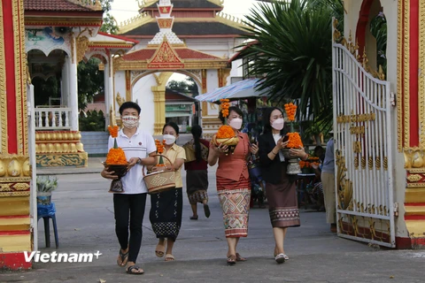 Người dân đi vào khu ThatLuang để dự Lễ ThatLuang. (Ảnh: Phạm Kiên/Vietnam+) 