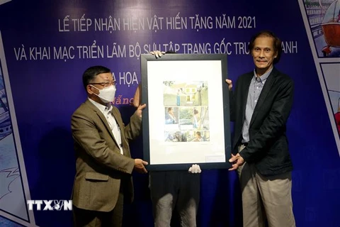 Đại diện họa sỹ Vĩnh Khoa (bên phải) trao tặng hiện vật tranh cho Bảo tàng Mỹ thuật Đà Nẵng tại buổi lễ. (Ảnh: Trần Lê Lâm/TTXVN) 
