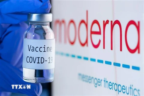 Vaccine ngừa COVID-19 bên biểu tượng của Hãng dược phẩm Moderna. (Ảnh: AFP/TTXVN) 