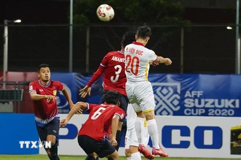 Tiền vệ Phan Văn Đức tranh bóng trên không với các cầu thủ Lào. (Ảnh: TTXVN phát) 