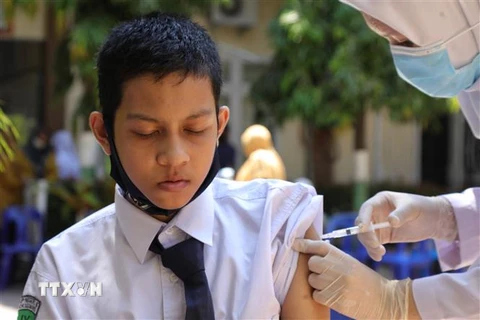 Nhân viên y tế tiêm vaccine ngừa COVID-19 cho học sinh tại tỉnh Aceh, Indonesia. (Ảnh: AFP/TTXVN) 