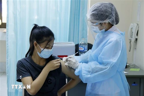 Một học sinh trên 12 tuổi tiêm vaccine ngừa COVID-19 tại bệnh viện Setthathirath, thủ đô Vientiane. (Ảnh: Phạm Kiên/TTXVN) 