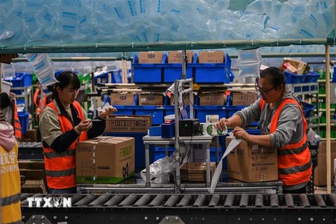 Nhân viên đóng gói hàng hóa tại một chi nhánh kho vận của Alibaba ở Vô Tích, tỉnh Giang Tô, Trung Quốc. (Ảnh: AFP/TTXVN) 