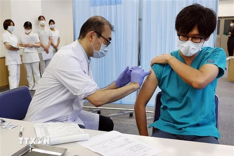 Nhân viên y tế tiêm vaccine phòng COVID-19 cho người dân tại Tokyo, Nhật Bản ngày 1/12/2021. (Ảnh: AFP/TTXVN) 
