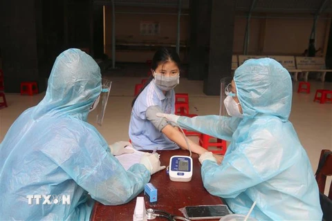 Khám sàng lọc trước khi tiêm vaccine phòng COVID-19 cho học sinh lớp 7 tại Trường trung học cơ sở Trần Quốc Tuấn (thành phố Trà Vinh). (Ảnh: Thanh Hòa/TTXVN) 