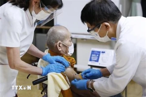 Nhân viên y tế tiêm vaccine ngừa COVID-19 cho người dân tại Tokyo, Nhật Bản, ngày 20/12/2021. (Ảnh: Kyodo/TTXVN) 
