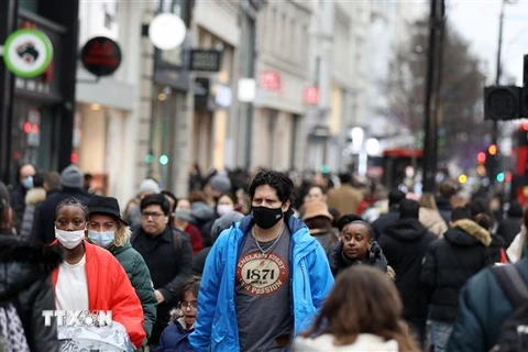 Người dân đeo khẩu trang phòng dịch COVID-19 tại London, Anh ngày 26/12/2021. (Ảnh: THX/TTXVN) 