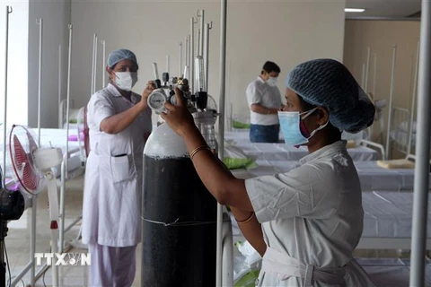 Nhân viên y tế chuẩn bị bình ôxy cho bệnh nhân COVID-19 tại Kolkata, Ấn Độ. (Ảnh: THX/TTXVN) 