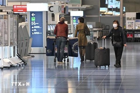 Hành khách làm thủ tục tại sân bay Haneda ở thủ đô Tokyo, Nhật Bản. (Ảnh: AFP/TTXVN) 