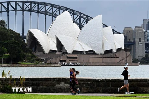Người dân tập thể dục tại khu vực Cầu Cảng ở thành phố Sydney, Australia. (Ảnh: AFP/TTXVN) 