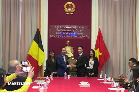 Đại sứ Nguyễn Văn Thảo tặng hoa cho Tân Chủ tịch Hội Sinh viên Việt Nam tại Bỉ. (Ảnh: Đức Hùng/Vietnam+) 