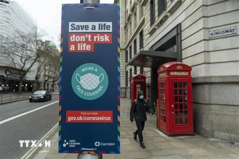 Biển hiệu khuyến khích người dân đeo khẩu trang phòng dịch COVID-19 tại London, Anh ngày 21/2/2022. (Ảnh: THX/TTXVN) 