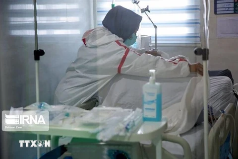 Nhân viên y tế điều trị cho bệnh nhân COVID-19 tại bệnh viện ở Iran. (Ảnh: IRNA/TTXVN) 