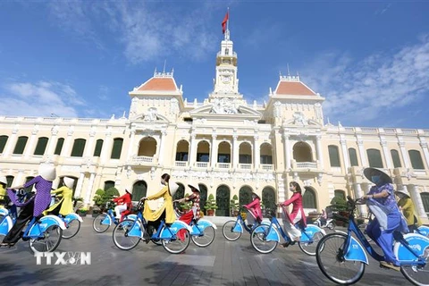 Đại biểu tham gia Chương trình diễu hành Áo dài 'Tôi yêu Áo dài Việt Nam' bằng xe đạp qua các tuyến phố. (Ảnh: Mỹ Phương/TTXVN) 
