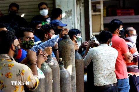 Người dân xếp hàng chờ bơm đầy bình ôxy để cung cấp cho bệnh nhân COVID-19 tại New Delhi, Ấn Độ. (Ảnh: THX/ TTXVN) 