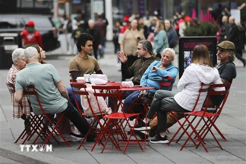 Người dân thư giãn tại một quán ăn ngoài trời ở quảng trường Thời đại, New York (Mỹ) khi các quy định phòng dịch COVID-19 được nới lỏng, ngày 7/3/2022. (Ảnh: THX/TTXVN) 