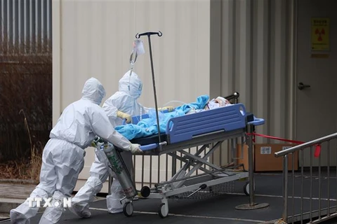 Nhân viên y tế chuyển bệnh nhân COVID-19 vào bệnh viện ở Seoul, Hàn Quốc ngày 14/3/2022. (Ảnh: Yonhap/TTXVN) 