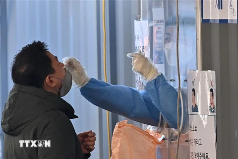 Nhân viên y tế lấy mẫu xét nghiệm COVID-19 cho người dân tại Seoul, Hàn Quốc ngày 2/3/2022. (Ảnh: AFP/TTXVN) 