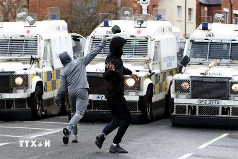 Người biểu tình ném đá vào lực lượng cảnh sát tại thành phố Belfast, Bắc Ireland, ngày 8/4/2021. (Ảnh: AFP/TTXVN) 