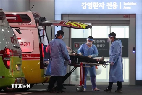 Nhân viên y tế chuyển bệnh nhân COVID-19 tới bệnh viện tại Seoul, Hàn Quốc, ngày 22/3/2022. (Ảnh: THX/TTXVN) 