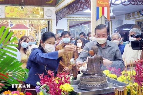 Bà Wiraka Mudhitaporn, Tổng lãnh sự Thái Lan tại Thành phố Hồ Chí Minh (trái) thực hiện nghi thức tắm Phật tại lễ hội. (Ảnh: Xuân Khu/TTXVN) 