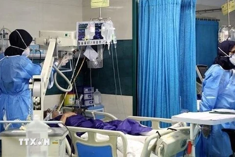 Nhân viên y tế điều trị cho bệnh nhân COVID-19 tại bệnh viện ở Iran. (Ảnh: IRNA/TTXVN) 