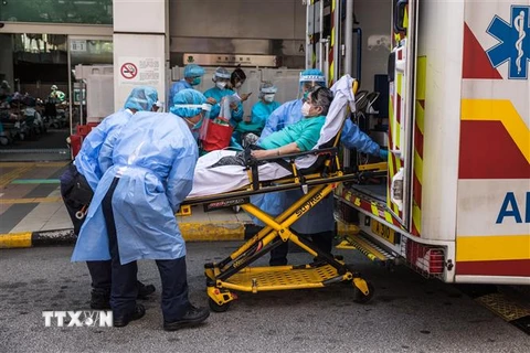 Nhân viên y tế chuyển bệnh nhân COVID-19 vào bệnh viện ở Hong Kong, Trung Quốc ngày 11/3/2022. (Ảnh: AFP/TTXVN) 