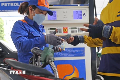 Người dân mua xăng dầu tại một cửa hàng của Petrolimex. (Ảnh: Trần Việt/TTXVN) 