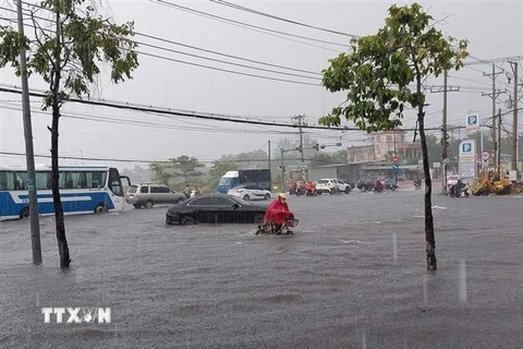 Nhiều xe chết máy khi đi qua đoạn ngập Suối Cát trên đại lộ Bình Dương thuộc địa bàn giáp ranh giữa thành phố Thủ Dầu Một và thành phố Thuận An. (Ảnh: TTXVN) 
