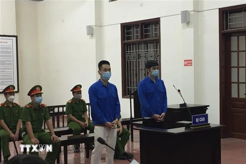 Hai bị cáo Trần Mạnh Linh và Nguyễn Tiến Minh tại phiên tòa xét xử. (Ảnh: Vũ Hà/TTXVN) 