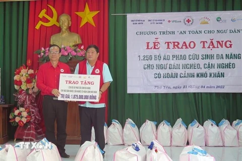 Phó Chủ tịch Hội Chữ thập Đỏ Việt Nam Vũ Thanh Lưu trao biển tượng trưng hỗ trợ áo phao cho ngư dân khó khăn. (Ảnh: Xuân Triệu/TTXVN) 
