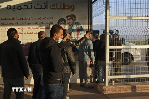Người lao động Palestine chờ qua cửa khẩu Erez vào Israel ngày 23/2/2022. (Ảnh: AFP/TTXVN) 