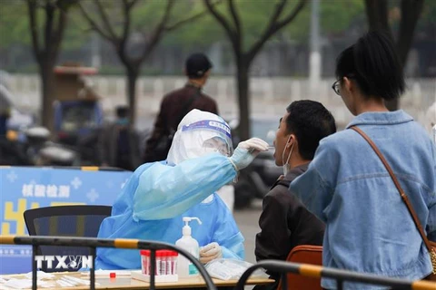 Nhân viên y tế lấy mẫu xét nghiệm COVID-19 cho người dân tại Bắc Kinh, Trung Quốc, ngày 25/4/2022. (Ảnh: THX/TTXVN) 