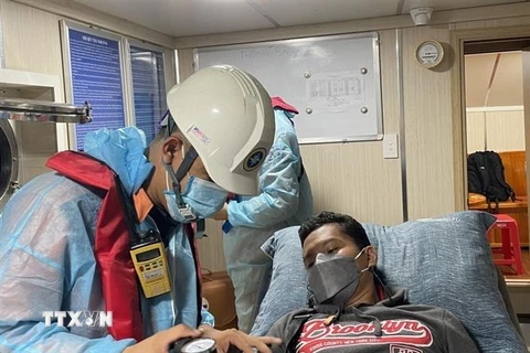 Thủy thủ người nước ngoài, anh Nuneza Japhet Cabahug (sinh năm 1986, quốc tịch Philippines) được các lực lượng cứu nạn, y tế kiểm tra sức khỏe trước khi đưa vào bờ điều trị. (Ảnh: TTXVN phát) 
