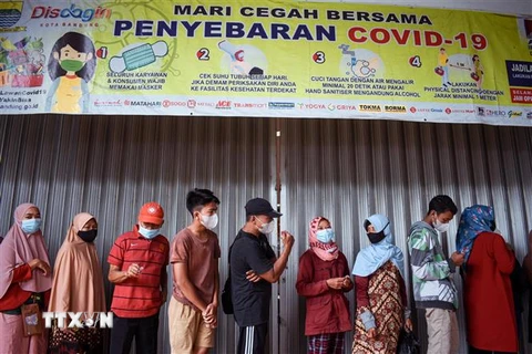 Người dân đeo khẩu trang xếp hàng mua thực phẩm tại Bandung, Indonesia, ngày 18/2/2022. (Ảnh: AFP/TTXVN) 
