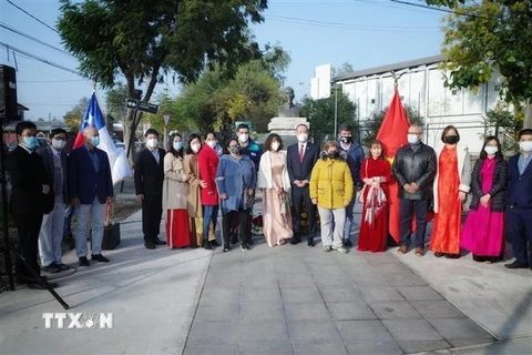 Cán bộ đại sứ quán Việt Nam cùng đại diện chính quyền Quận Cerro Navio tại tượng đài Chủ tịch Hồ Chí Minh. (Ảnh: TTXVN phát) 