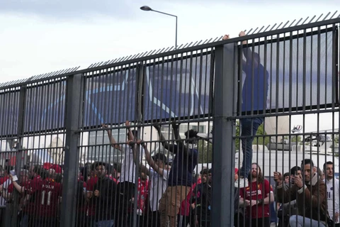 Cổ động viên trèo qua hàng rào để vào sân. (Nguồn: AP) 