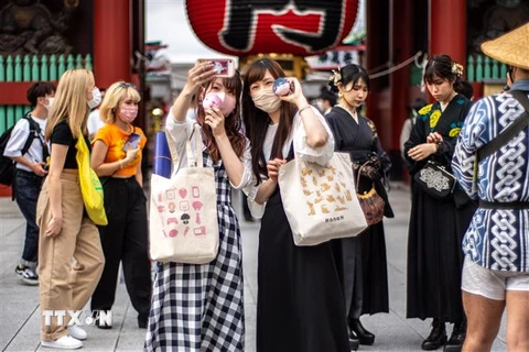 Du khách chụp ảnh tại một điểm du lịch ở Tokyo, Nhật Bản. (Ảnh: AFP/TTXVN) 