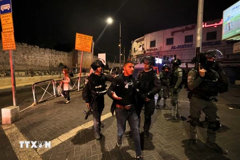 Lực lượng an ninh Israel bắt giữ đối tượng quá khích trong cuộc đụng độ với người Palestine tại khu vực đền Al-Aqsa/Núi Đền ở Jeruslem, ngày 16/5/2022. (Ảnh: AFP/TTXVN) 