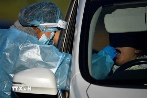 Nhân viên y tế lấy mẫu xét nghiệm người nhiễm COVID-19 tại Sydney, Australia. (Ảnh: AFP/TTXVN) 
