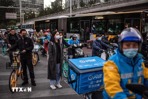 Người dân đeo khẩu trang phòng dịch COVID-19 tại Trung Quốc. (Ảnh: AFP/TTXVN) 