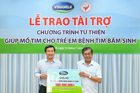 Ông Đỗ Thanh Tuấn, Giám đốc Đối Ngoại Vinamilk (bên trái) đại diện trao kinh phí hỗ trợ chương trình mổ tim miễn phí cho các bệnh nhi có hoàn cảnh khó khăn. (Nguồn: Vietnam+) 