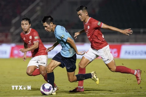 Pha tranh bóng giữa cầu thủ đội bóng Câu lạc bộ Thành phố Hồ Chí Minh (áo đỏ) và cầu thủ Hồng Lĩnh Hà Tĩnh (áo xanh). (Ảnh: Thanh Vũ/TTXVN) 