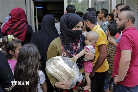 Người dân xếp hàng mua bánh mì tại Beirut, Liban. (Ảnh: AFP/TTXVN) 