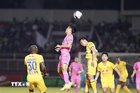 Pha tranh bóng giữa cầu thủ đội bóng đá Sài Gòn FC (áo hồng) với đội bóng Hoàng Anh Gia Lai (áo vàng). (Ảnh: Thanh Vũ/TTXVN) 