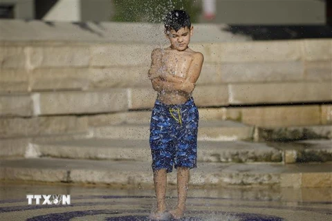 Trẻ nhỏ làm mát do nhiệt độ lên cao kỷ lục ở San Antonio, Texas, Mỹ ngày 18/7/2022. (Ảnh: THX/TTXVN) 