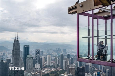 Khách du lịch chụp ảnh tại tòa tháp ở thủ đô Kuala Lumpur, Malaysia. (Ảnh: AFP/TTXVN) 