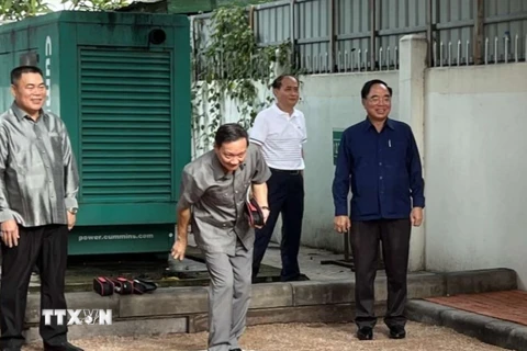 Đại sứ Nguyễn Bá Hùng tham gia giao lưu môn bi sắt với đội Lào. (Ảnh: Phạm Kiên/TTXVN) 
